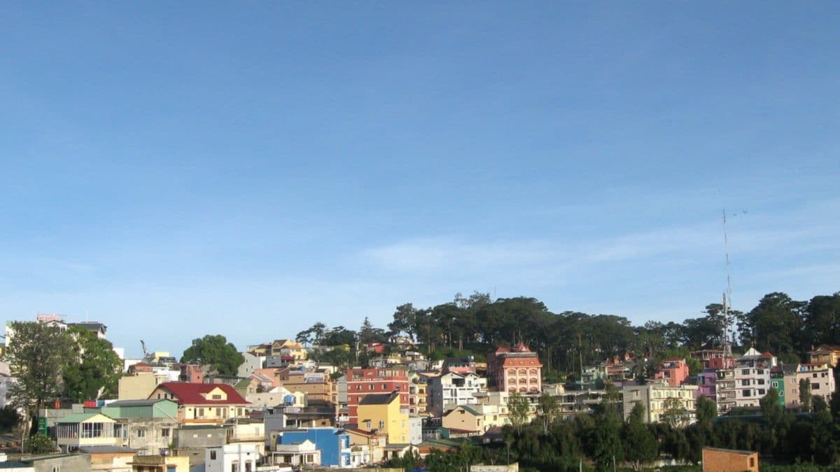 Colorful houses on a hillside in central Da Lat under a clear blue sky