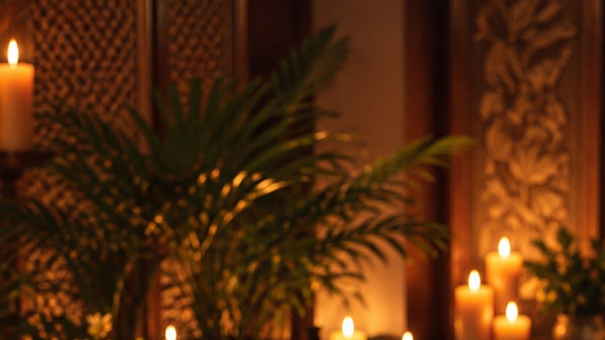 Lá cây xanh và những ngọn nến thắp sáng trước vách gỗ chạm hoa văn