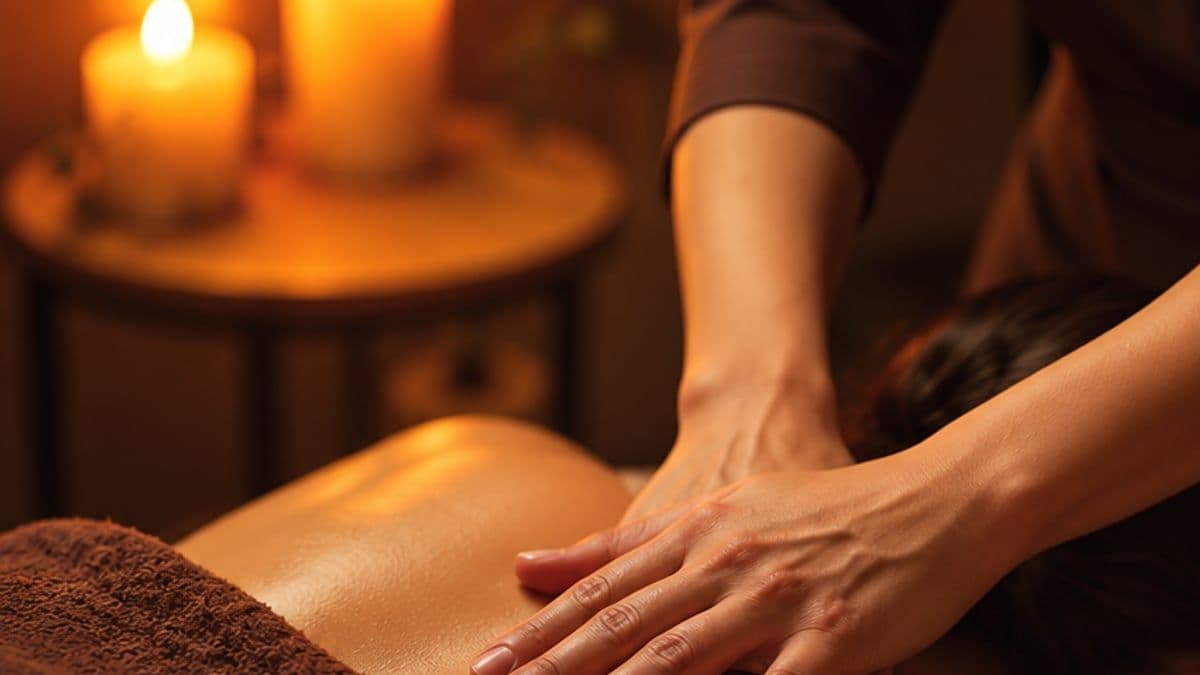 Hai tay kỹ thuật viên massage vùng lưng trên và vai của khách