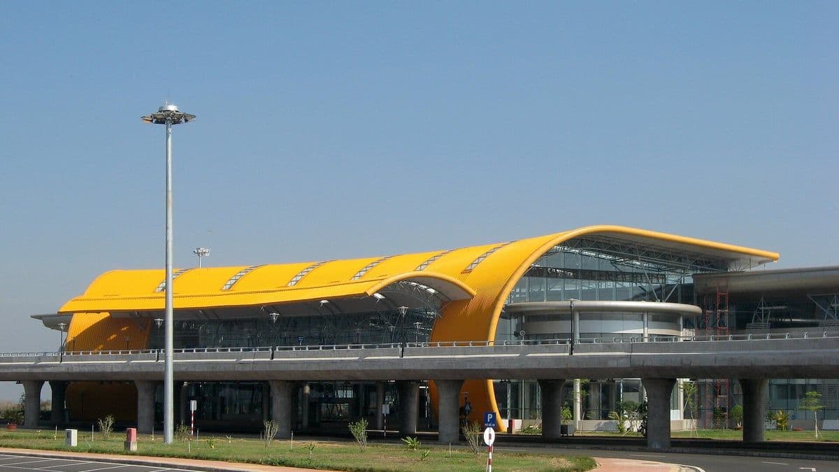 The terminal of Lien Khuong Airport with its curved yellow roof under a clear blue sky