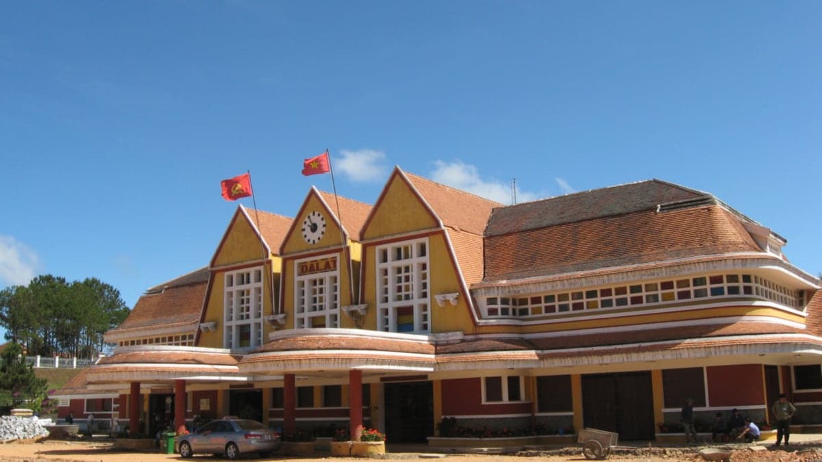 Ga Đà Lạt với ba mái nhọn và hai lá cờ đỏ trên nền trời xanh