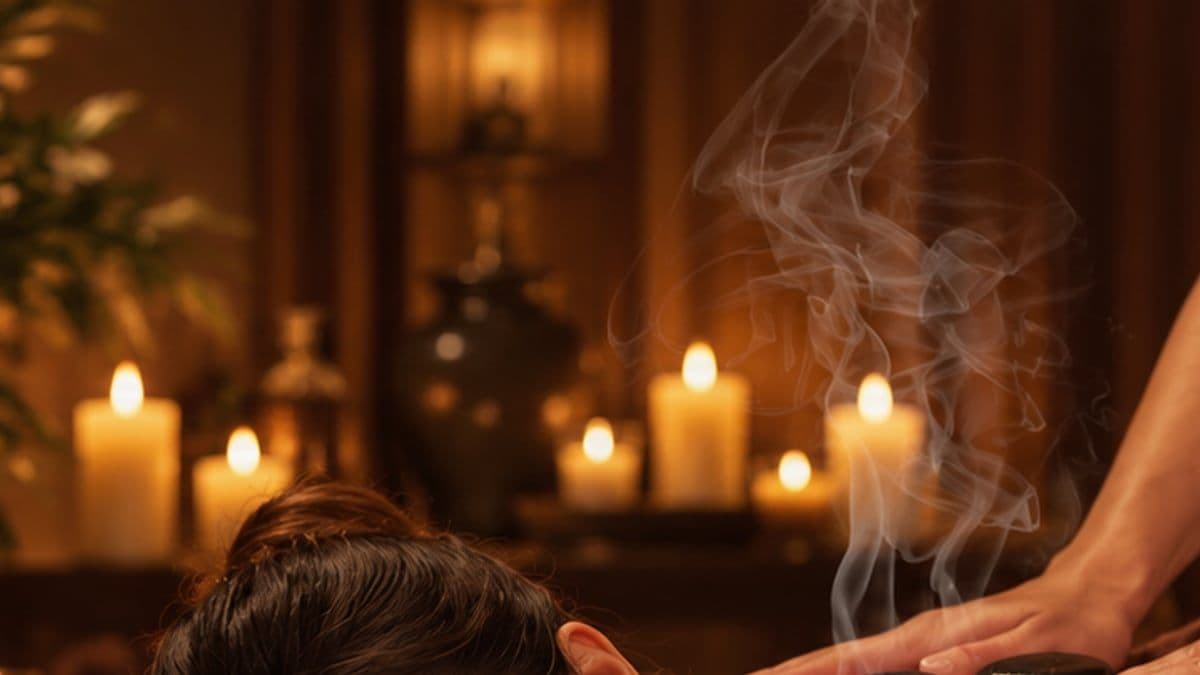 Hơi nóng bốc lên giữa ánh nến trong phòng massage, khách nằm sấp thư giãn